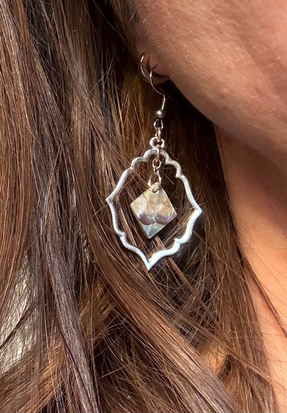 Exotic Silver earring with abalone pearl worn by a person with brown hair.