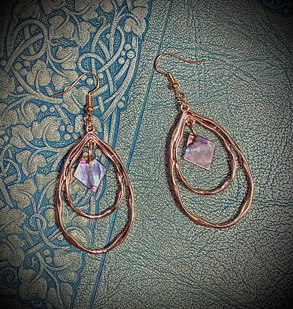 Pair of gold hoop earrings with a central abalone pearl from Martin Guitar custom inlays.