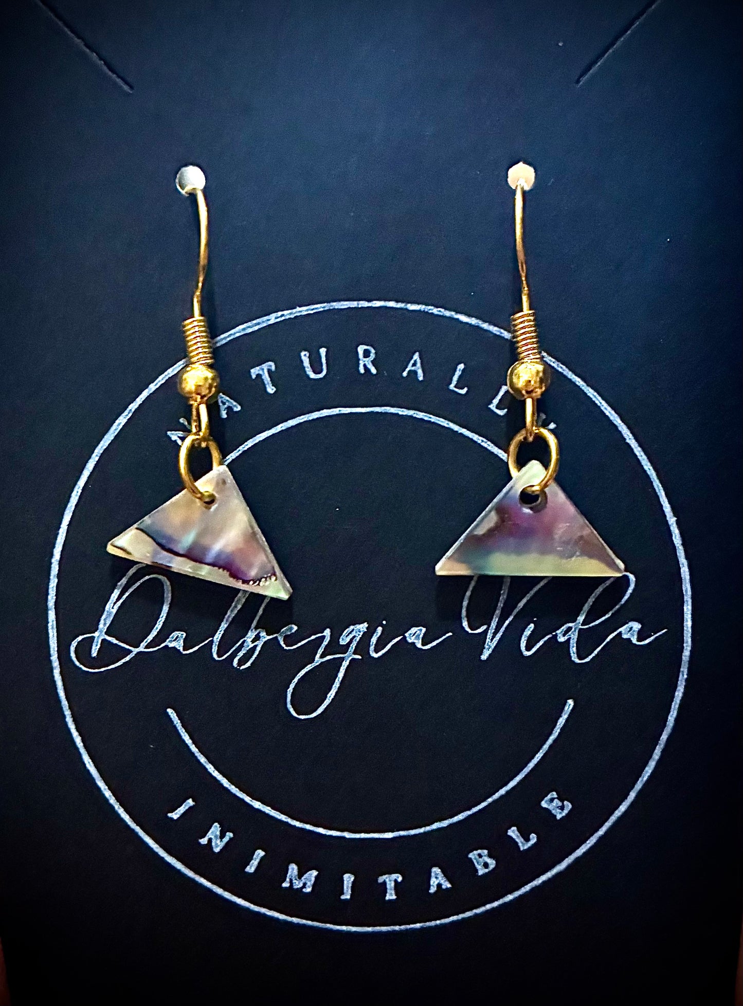 Triangular Abalone Pearl earrings with gold hooks on a dark background with visible branding. Sourced from Martin Guitar