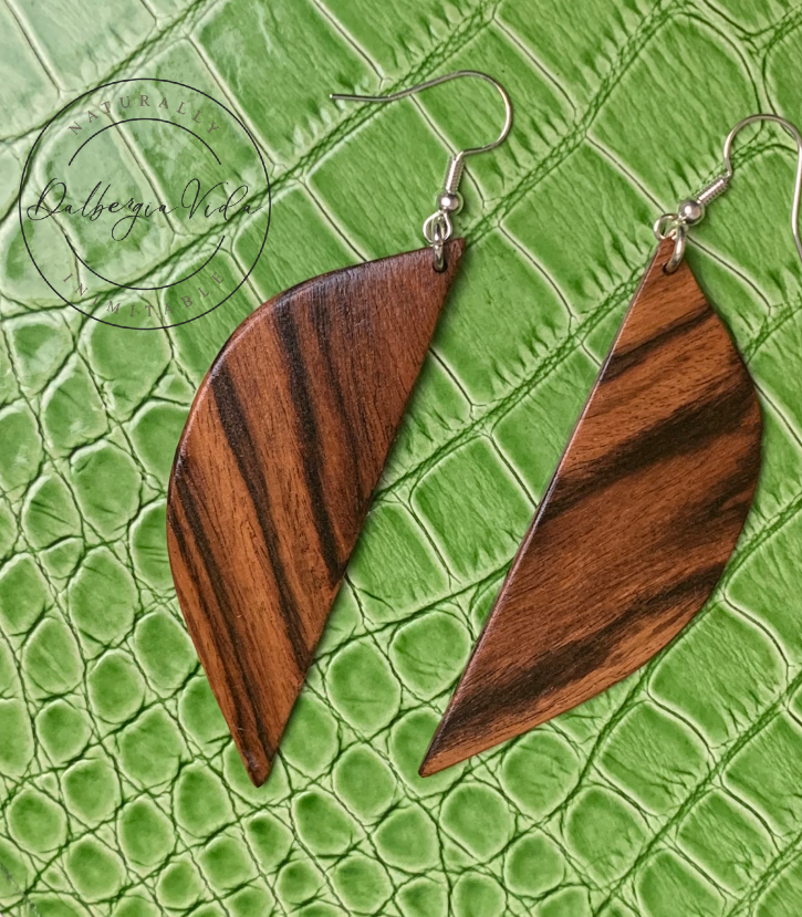 Wooden leaf-shaped earrings on a green textured background