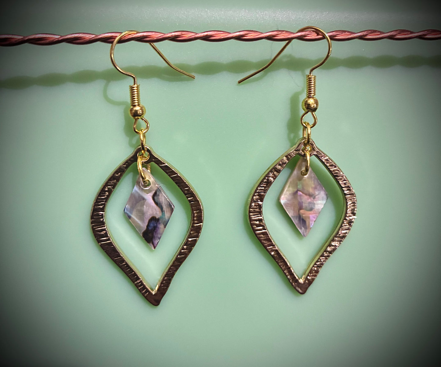 Gold shape earrings with abalone pearl diamond in center. Sourced from Martin Guitar.
