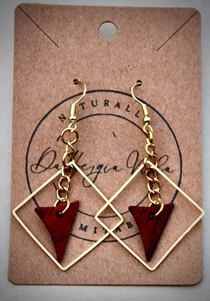 A pair of gold chain cocobolo earrings with red and brown wood coloring, displayed on a card with 'Dalbergia Vida' branding.