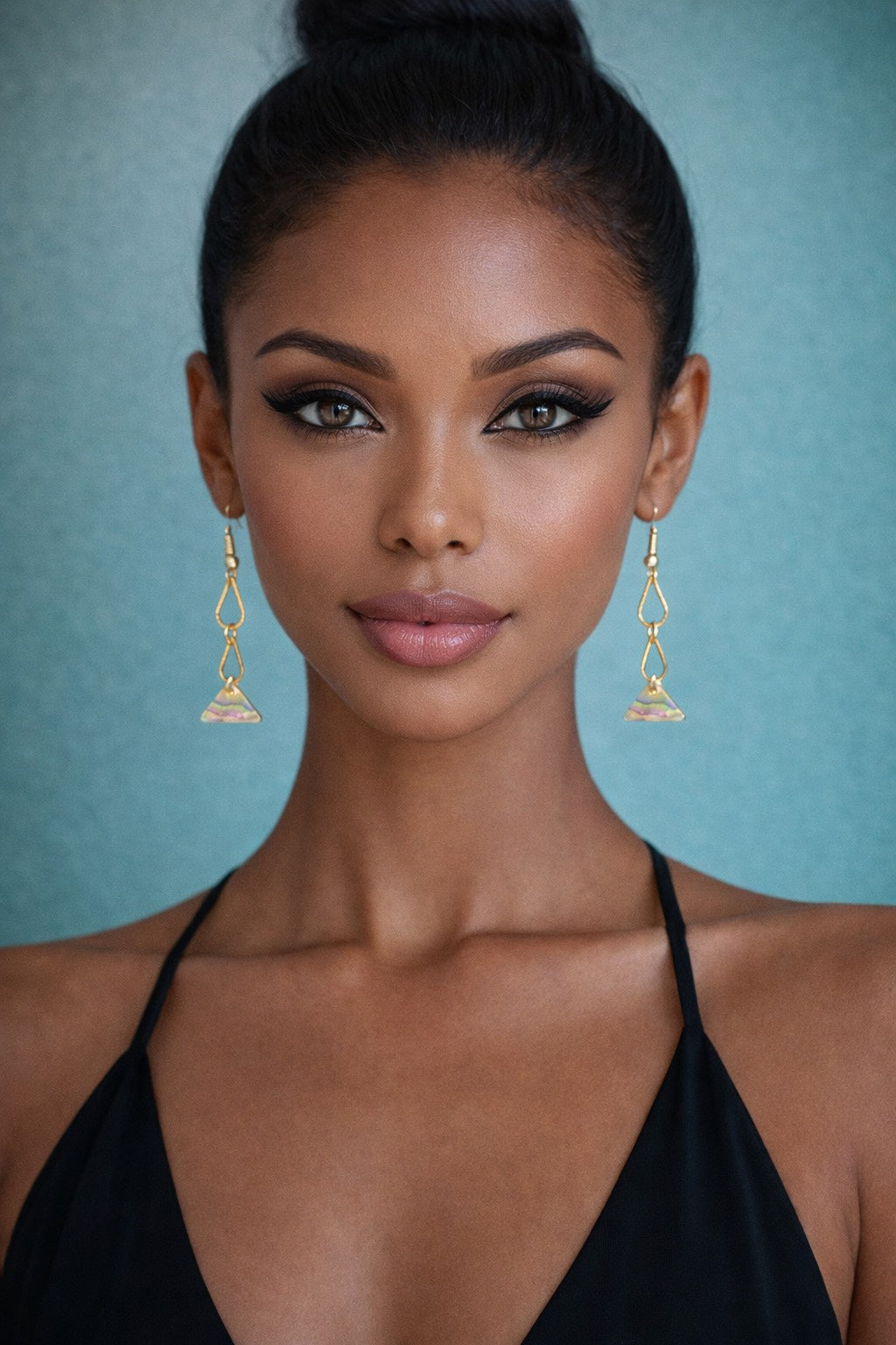 Woman wearing gold earrings against a blue background