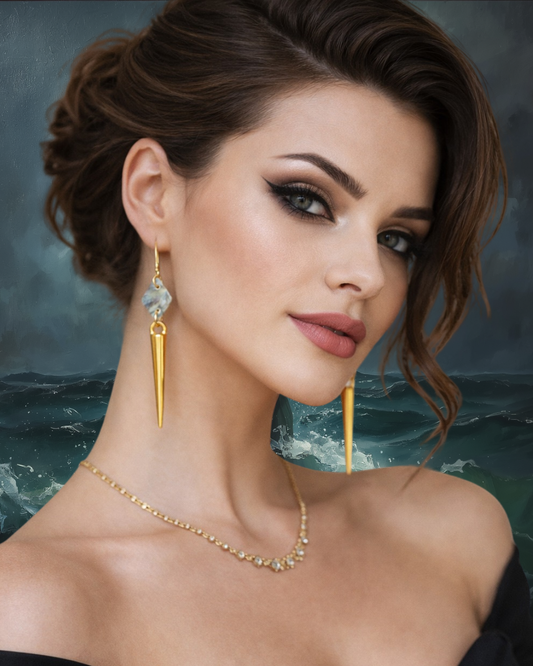 Woman wearing gold earrings and necklace with a blurred ocean background
