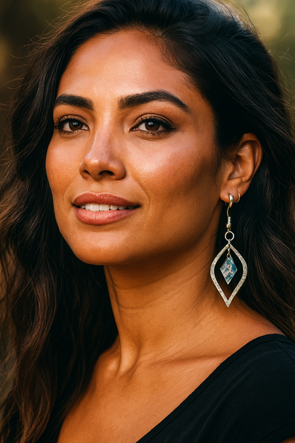 Woman wearing Silver Marquise Earrings with abalone pearl in center sourced from Martin Guitar with a blurred natural background