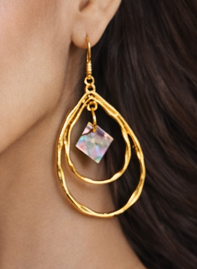 Gold hoop earrings with a central diamond abalone pearl from Martin Guitar Custom inlays worn by a person.
