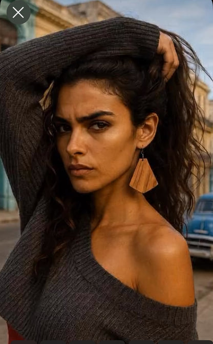 Cuban Woman wearing a dark gray off-shoulder sweater with a blurred urban background sporting Wild grain Rosewood guitar wood earrings.